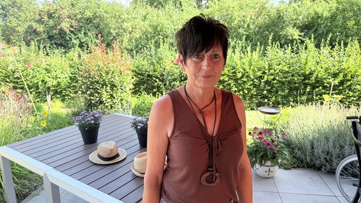 Eine Frau mit kurzen Haaren lächelt in die Kamera