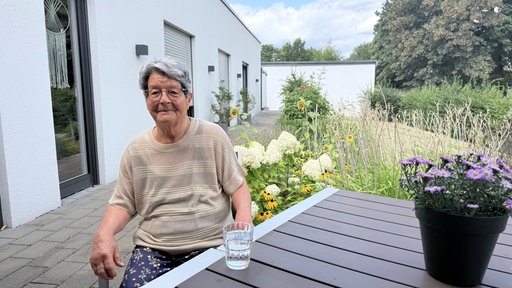 Eine Frau mit kurzen Haaren lächelt in die Kamera