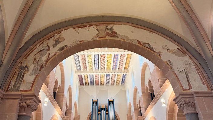 Ein Kirchenbogen mit einer Malerei, die nur zum Teil sichtbar ist