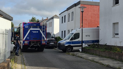 Auf einer Straße in Übach-Palenberg stehen Polizei und Technisches Hilfswerk.
