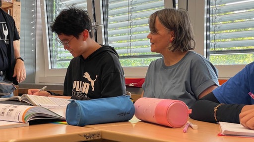Klassenzimmer am Einhard-Gymnasium Lehrerin sitzt neben einem Schüler