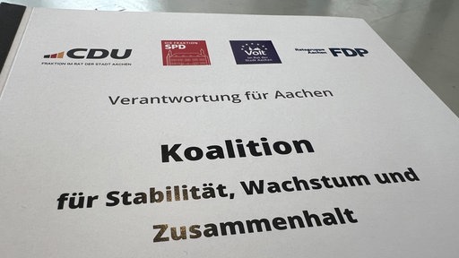 Auf einem Papier stehen die Logos von CDU, SPD, Volt und FDP; darunter "Koalition für Stabilität, Wachstum und Zusammenhalt"