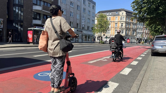 Auf einem Radweg in Aachen fährt ein E-Scooter hinter einem Fahrrad.