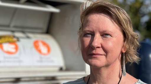 Ohlmann vor einem Altkleidercontainer