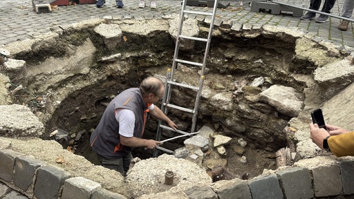 Stadtarchäologe Andreas Schaub bei Grabungsarbeiten am Münsterplatz in Aachen.