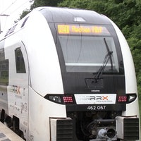 Ein Zug des Betreibers RRX mit der Anzeige Aachen Hbf steht am Bahnsteig