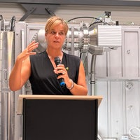 Drei Männer und eine Frau stehen nebeneinander, sie halten einen runden Chip in den Händen.