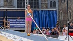 Springerin mit dem Hochsprungstab über der Schuler
