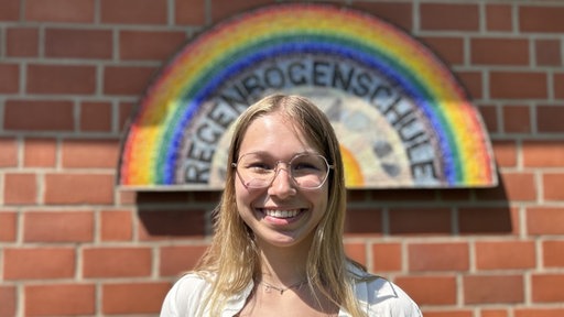 Mädchen steht vor Regenbogenschule in Stolberg