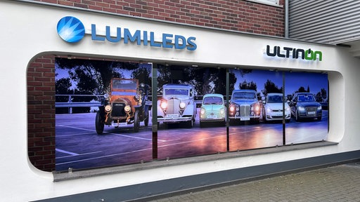 Eine Wand mit Schildern der Firma Ultinon Motion