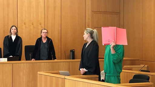 Der Angeklagte in grüner Kleidung vor der Urteilsverkündung.