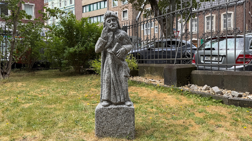 Eine Steinstatue steht im Kirchoh-Garten der St.Jakobskirche Aachen