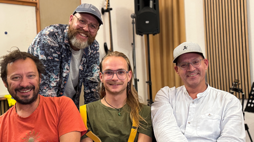 Vier Musiker spielen  auf einer Bühne