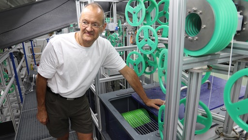 Klaus Vossenkaul steht vor einer Maschine zur Filtertechnik