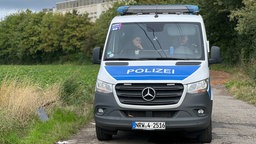 Polizeikräfte sitzen in einem Polizweiwagen nach einem Sabotageverdacht vor dem Umspannwerk Weisweiler.