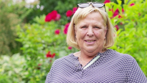 Simone Borsten steht in einem Garten.