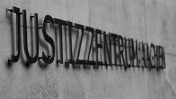 Ein Schriftzug des Justizzentrum Aachen ist am Gebäude von außen zu sehen.