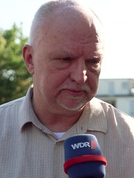 Ein Mann mit Glatze gibt ein Interview