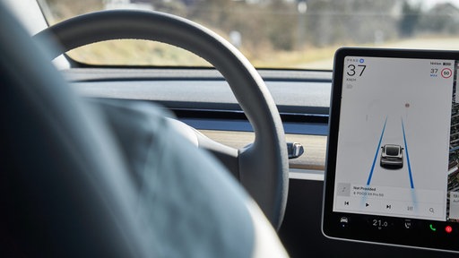 Das Display eines Tesla Model Y zeigt den Autopilot-Modus mit Spurführung