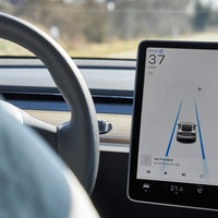 Das Display eines Tesla Model Y zeigt den Autopilot-Modus mit Spurführung