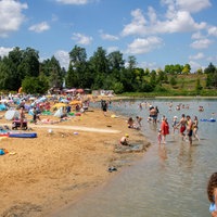 Seepark Zülpich: Badegäste im Wasser und am Sandstrand eines Badesees