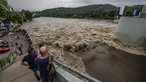 Einige Menschen stehen an der Stauwehre vom Baldeneysee und blicken auf die Wassermassen