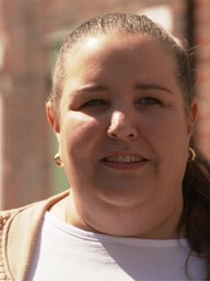 Eine Frau steht vor einem Backsteingebäude in einem Gewerbehof in Remscheid