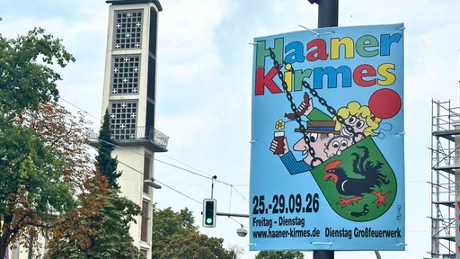 Ein Plakat der Haaner Kirmes 2026 hängt an einer Laterne