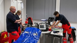 drei Einsatzkräfte bereiten einen Raum für überhitzte Personen vor