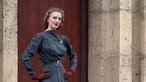 Lenina steht in einem Vintage Kleid vor einer Mauer