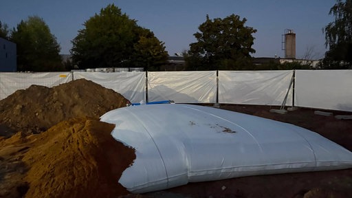 Eine Sprenggrube einer Weltkriegsbombe ist mit Sand und einem Wasserkissen befüllt.