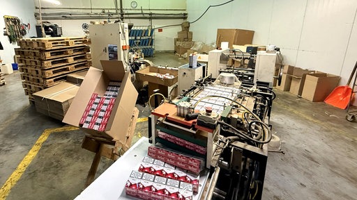Illegale Zigarettenfabrik. Fertigungsband mit Zigarettenschachteln.