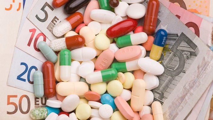 Geldscheine in einer Menge von bunten Tabletten und Pillen