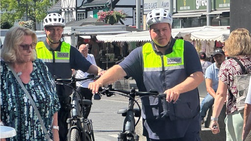 zwei Fahrradpolizisten gehen durch die Stadt