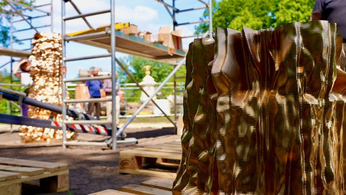 Eine goldene Skulptur und im Hintergrund ein Baugerüst.