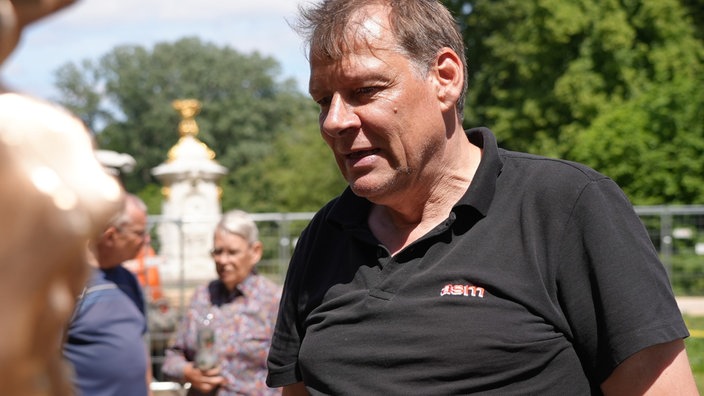 Mittelalter Mann mit kurzen Haaren und einem schwarzen Poloshirt.
