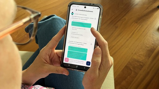Eine Person schaut auf ihr Handy