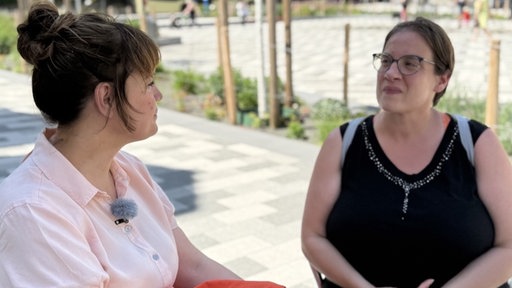 Frau mit Brille im schwarzen Top im Interview 