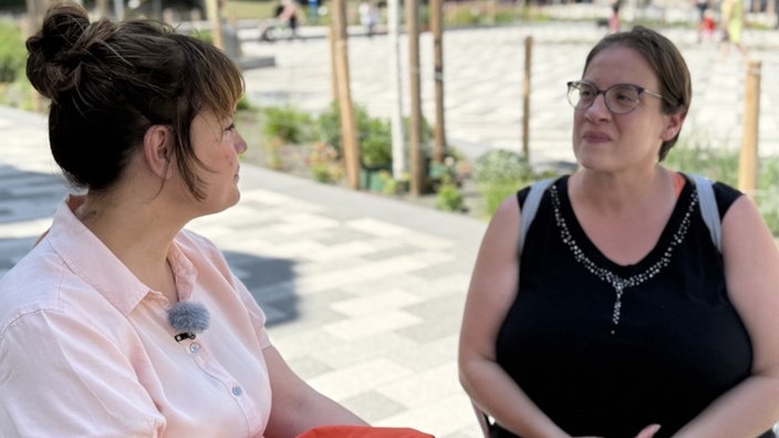 Frau mit Brille im schwarzen Top im Interview 