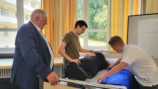 Herr Laumann am Kranknbett eines Patienten