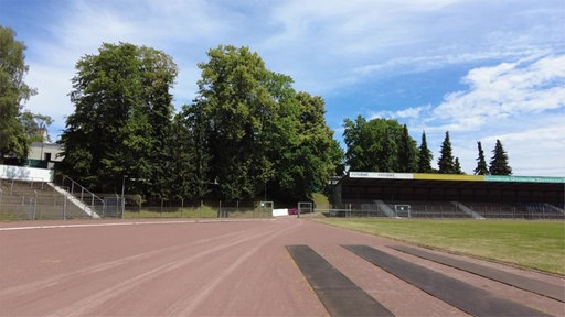 Sportplatz mit Tribüne und Rasen