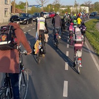 Viele Kinder und Erwachsene fahren gemeinsam in einer Kollone Fahrrad, sie demonstrieren