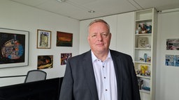 Ein Mann im Anzug steht in einem Büro.