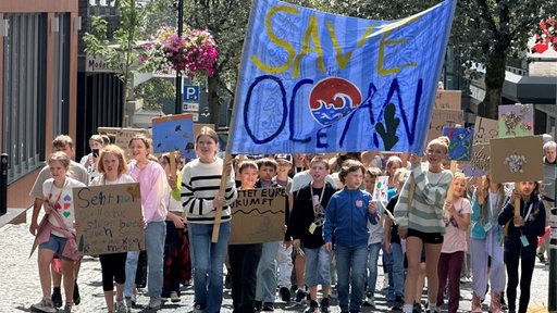 Kinder-Demo mit großem Banner "Save the Ocean"