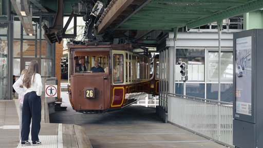Der historische Kaiserwagen der Wuppertaler Schwebebahn fährt in eine Station ein.