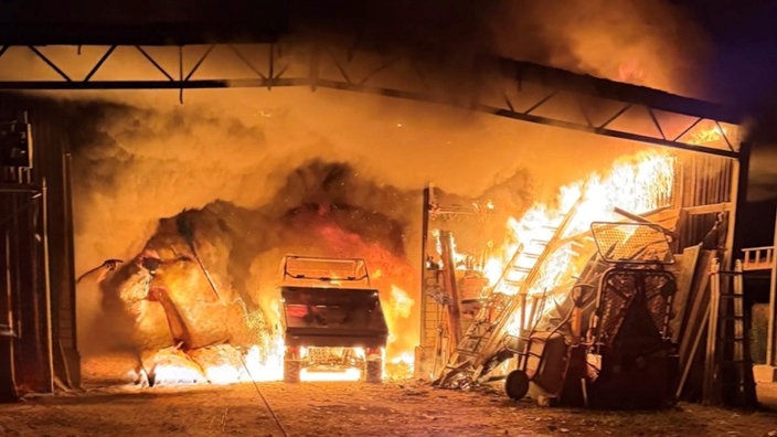 Flammen in einer Lagerhalle, in der landwirtschaftliche Geräte stehen