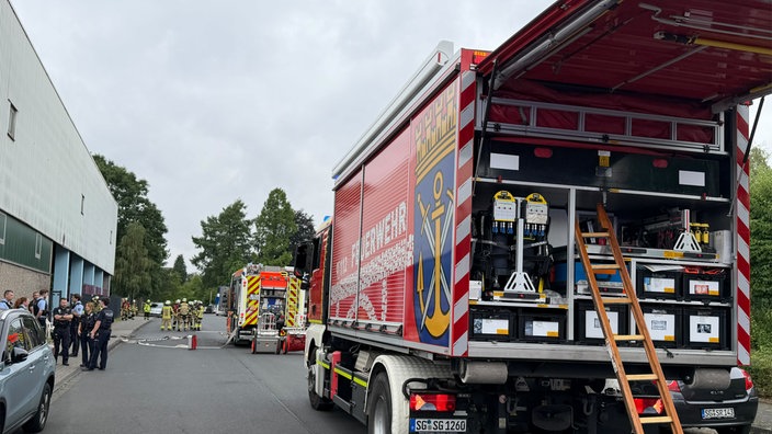Zwei Feuerwehrfahrzeuge und mehrere Feuerwehrleute im Einsatz