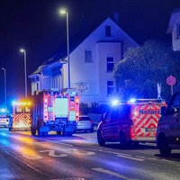 In Solingen stehen Notarzt- und Rettungswägen in der Nacht auf einer bewohnten Straße, entlang der einige Straßenlaternen stehen