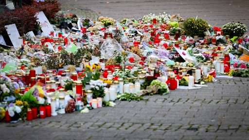 Bild einer TTrauerstätte mit Kerzen, Blumen und Briefen