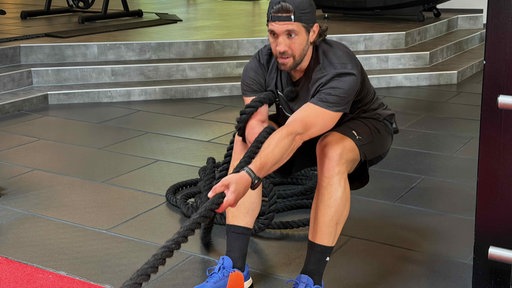 Mann beim Tauziehen in Fitnessstudio